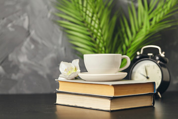 Alarm clock and cup of on wooden table, copy space for text or product display.
