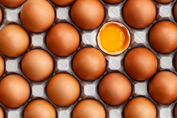 Whole brown chicken eggs and one broken egg