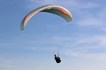 Paraglider flying wing in a blue sky	