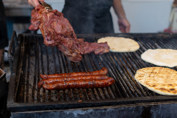 Chef preparing meat on the grill, during outdoor outside food festival