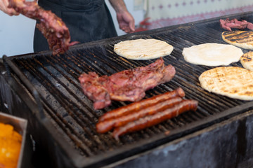 Chef preparing meat on the grill, during outdoor outside food festival
