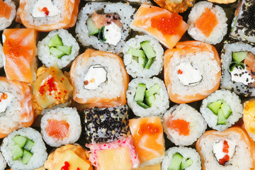 Japanese sushi food background. Maki ands rolls with tuna, salmon, shrimp, crab and avocado. Top view of assorted sushi roll