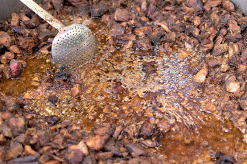 Unhealthy, greasy, oily, mix of meat slices, frying in a large pot, during fast food festival.