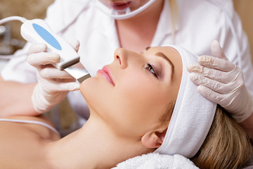 cosmetology and beauty concept - beautiful woman receiving ultrasound cavitation facial peeling - obrazy, fototapety, plakaty