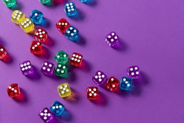 Bright and colorful dice set on violet background
