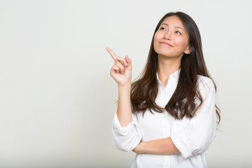 Portrait of young beautiful Asian businesswoman thinking