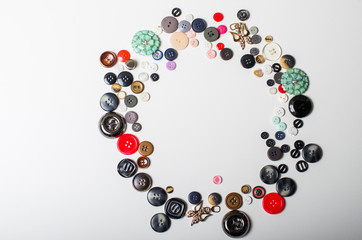 Threads and buttons of different colors on a white background.