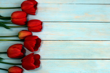 Red tulips on a wooden background with a place for inscription