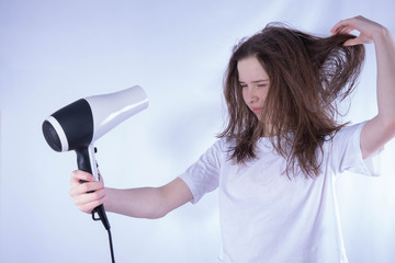 girl dries her hair with a hairdryer