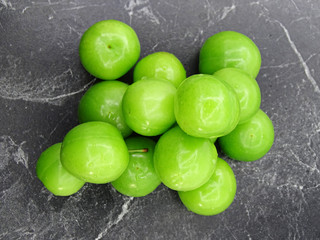 Green plums on grey background                                 
