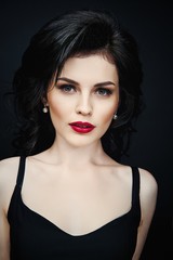 Portrait of gorgeous brunette woman against studio background . Sensual young woman with red lips and bright makeup. Beautiful healthy face of the young pretty woman with fresh skin.