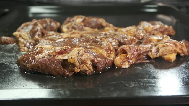 Panning shot of marinated lamb in the tray before grilled.