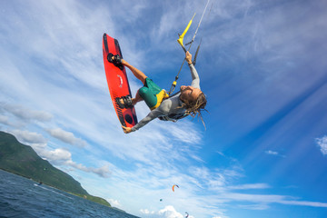 professional kiter makes the difficult trick on a beautiful background of spray and beautiful clouds of Mauritius