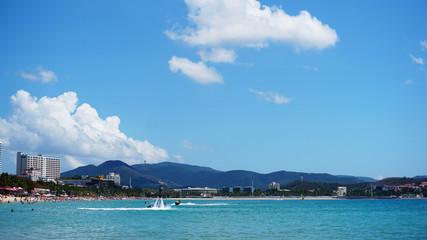 Man posing at new flyboard at beach far away - summer time