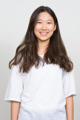 Portrait of happy young beautiful Asian woman smiling