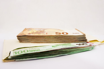 stacks with euro on white. Banknotes in an envelope. Close-up. Much money.