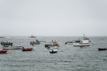 Fototapeta na wymiar Corrubedo, Spain; Aug 10 2019: Typical fishing boats from northern spain floating in misty day
