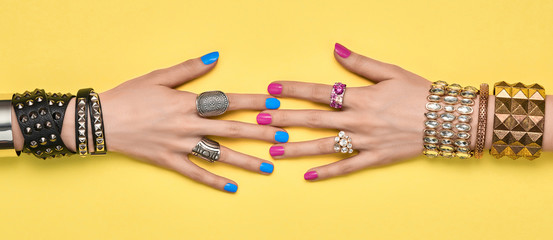 Fashion. Female hand, Stylish jewelry. Minimal design. Summer hipster woman luxury accessories, bracelets ring. Creative art friendship concept Trendy jewelry on yellow, banner