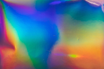 high res macro photo of abstract pastel iridescent holographic foil background with light leaks....