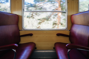 Interior of old train with leather seats and view out the window