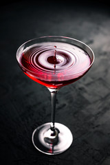 A drop falling into a beautiful cocktail glass with cosmopolitan