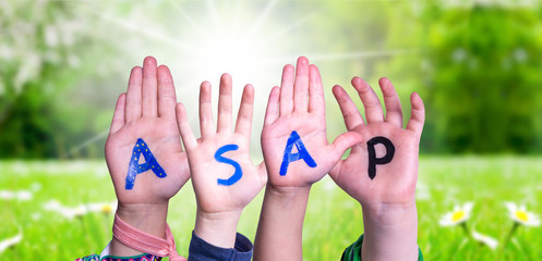 Children Hands Building Colorful English Word ASAP. Sunny Green Grass Meadow As Background