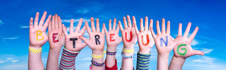 Kids Hands Holding Colorful German Word Betreuung Means Day Care. Blue Sky As Background
