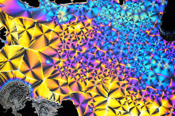 Colorful micro crystals in polarized light. Photo through a microscope.