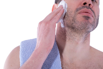 Obraz premium man puts shaving foam on his face