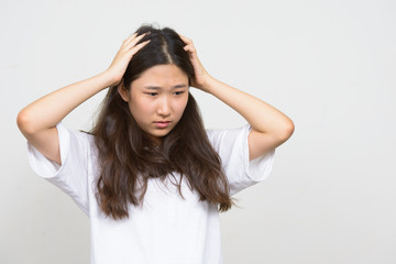 Fototapeta premium Portrait of stressed young Asian woman having headache