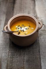 Pumpkin soup with pumpkin seeds.
Appetizing dish on a wooden table.
