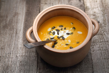 Creamy pumpkin soup.
Appetizing dish on a wooden table.