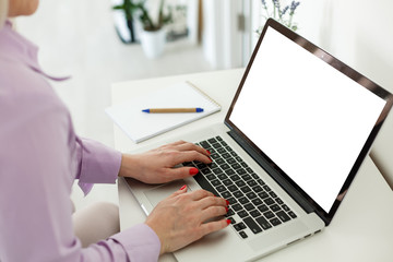 view of young successful female freelancer use laptop for distance work during her recreation time, woman's hands keyboarding on portable laptop computer with blank copy space on the screen