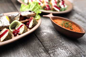 Whole smoked trout and sheep's cheese in herbs smoked. A traditional platter of cold snacks.