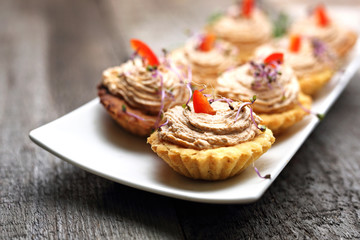 Fototapeta na wymiar Dry muffins stuffed with liver mousse. Appetizing dish on a wooden table.