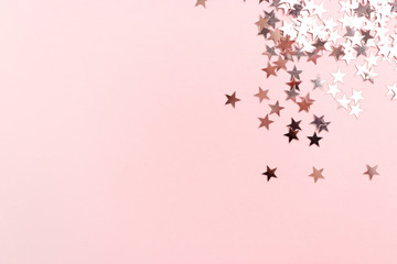 Stars glitter scattered on pink pastel background. Monochromatic concept with place for your text.