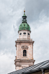 Fototapeta na wymiar Steeple with onion dome of St. Peter Abbey in old town of Salzburg, Austria