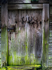 Old vintage door with horseshoes on the barn