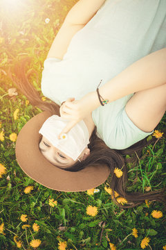 young woman sitting on the grass with flu mask 