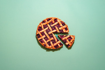 Blueberries pie with lattice crust top view on a green background.