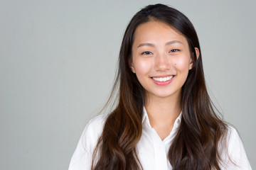 Face of happy young beautiful Asian businesswoman smiling