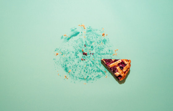 Last slice of cake on a green background. Blueberry pie slice.