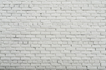 White wall of the house. Old brick wall. White paint on a brick wall.