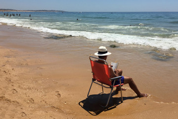 hombre leyendo en la playa