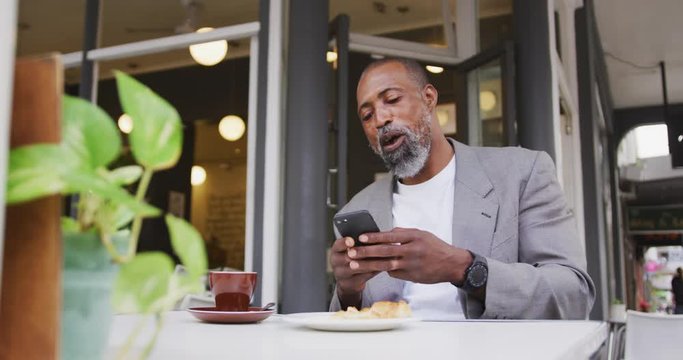African American man using his phone in a coffee