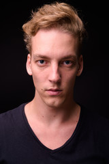 Obraz premium Face of young blond Scandinavian man against black background