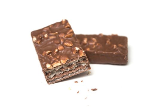 Closeup of crunched chocolate bar with nuts on white background