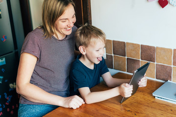 Skype and Zoom family chat. Mom and son are talking on an online conference call. Family joy....