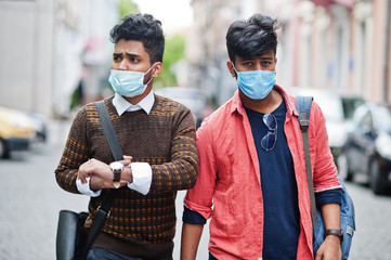 Coronavirus covid-19 concept. Two south asian indian man wearing mask for protect from corona virus walking at city. New normal lifestyle post pandemic in India.