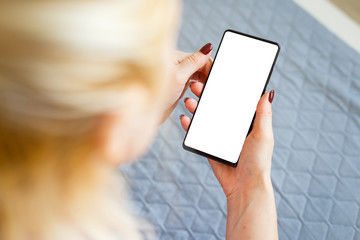 Close up Woman hand Using a Smart Phone on bed at home.